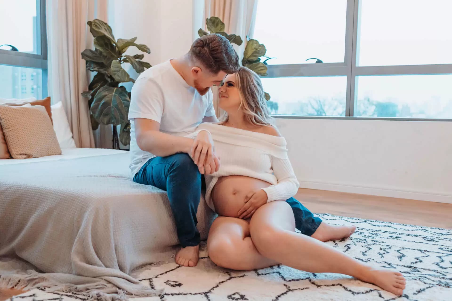 Casal se olhando na ponta da cama